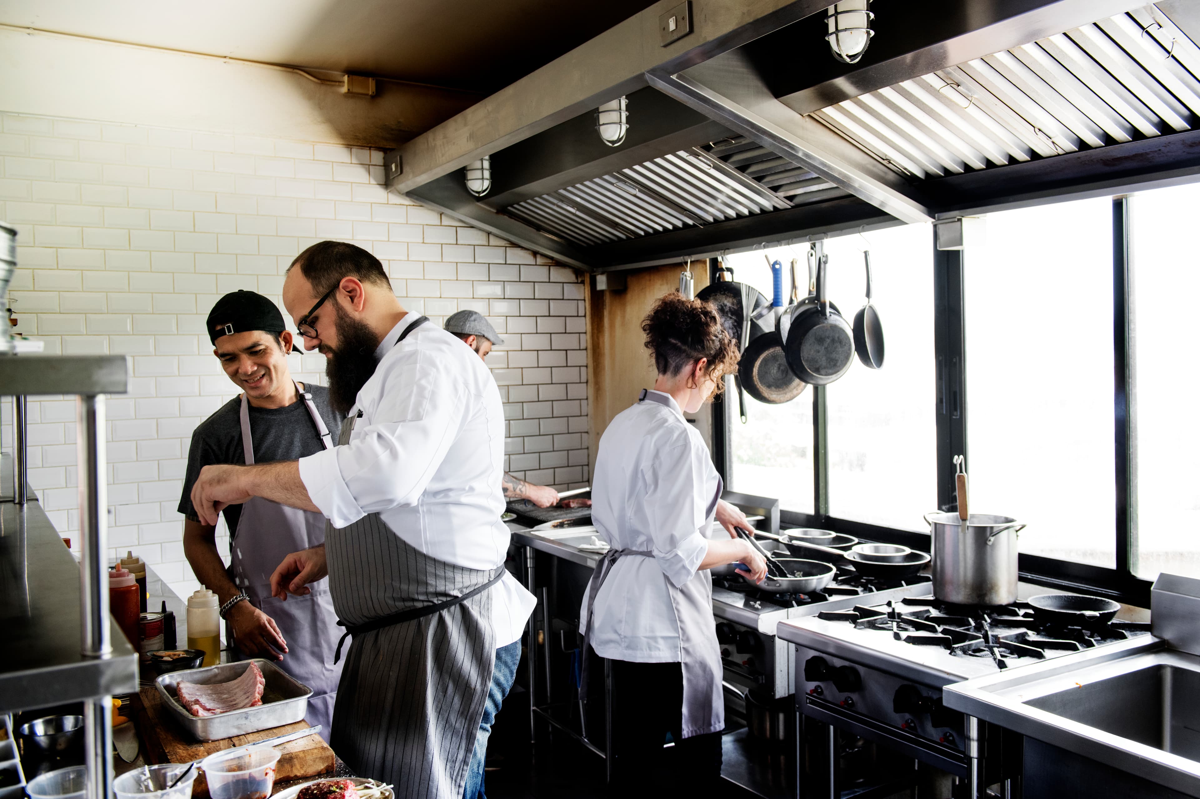 Busy restaurant kitchen during lunch rush with chefs working